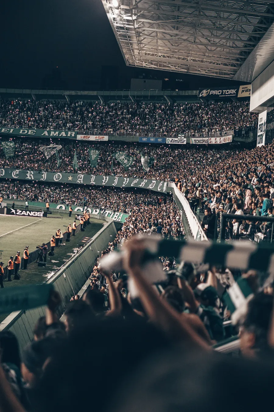 A packed football stadium under floodlights